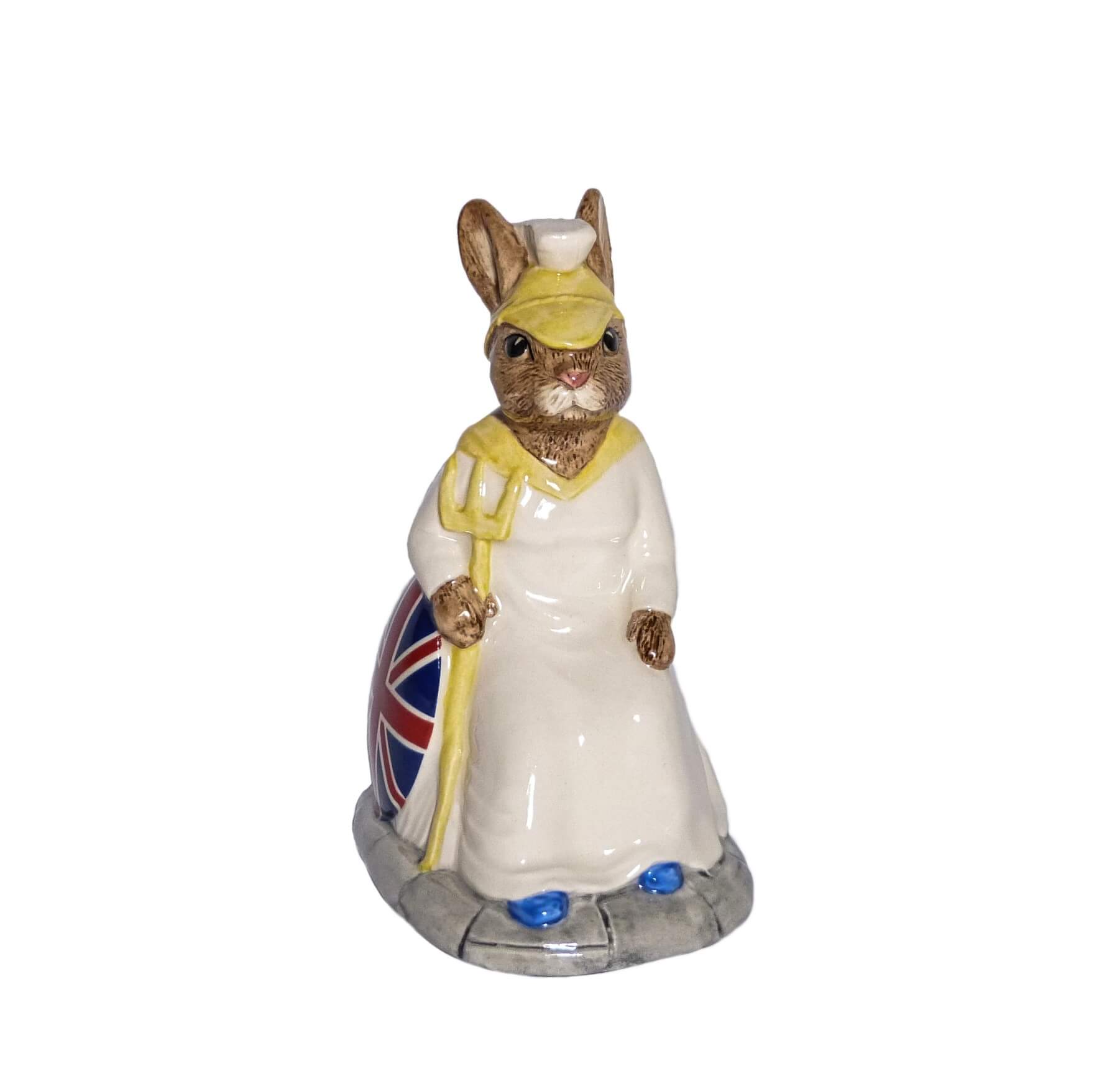 The figure is wearing a white gown and a helmet. She is holding a trident and has a shield painted with a red ,white and blue Union Jack.
