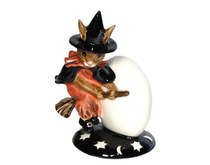 The bunny is wearing a red dress with frilled collar, black cape and black pointed witches hat. She is riding a broomstick near a moon with a black cat on the side.